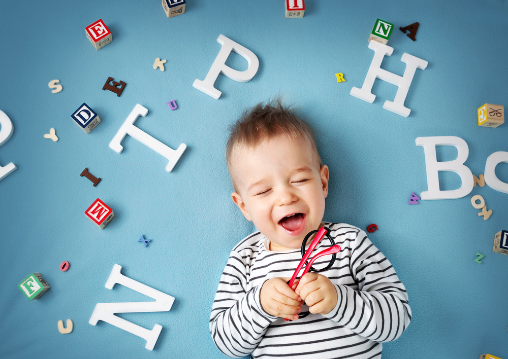 One,Year,Old,Child,Lying,With,Spectacles,And,Letters,On